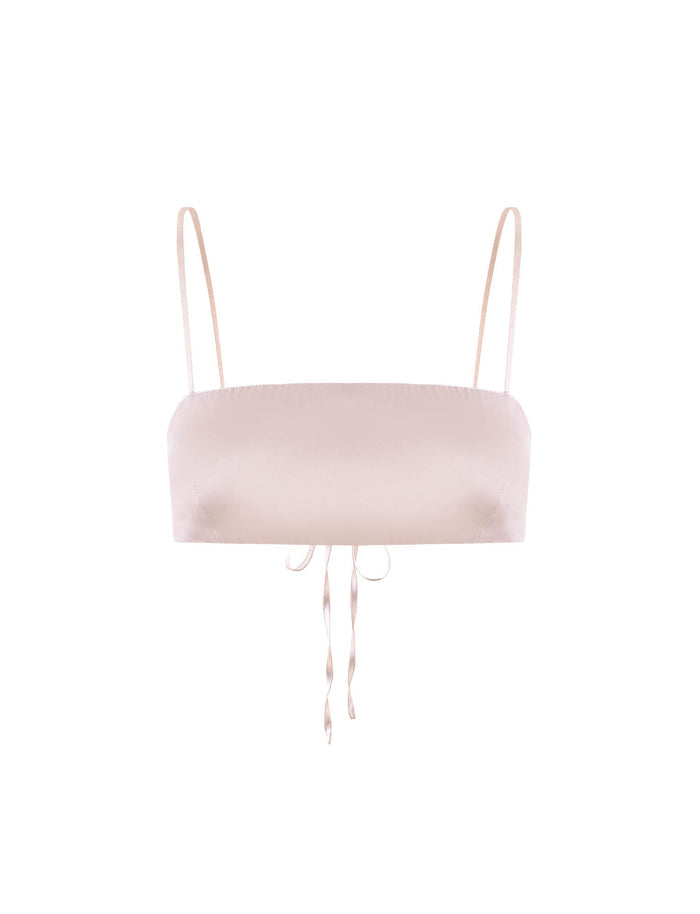 The ALINA TOP - WHITE : IVORY by TIGERMIST is a minimalistic bralette featuring thin adjustable straps and a small bow-tie detail at the center front. This light beige bralette boasts a sleek and smooth design, offering a simple yet elegant appearance.