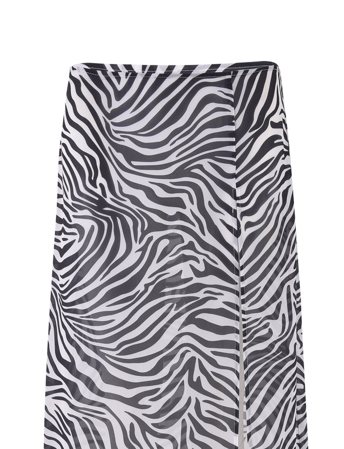 The AYESHA SKIRT - BLACK : ZEBRA by TIGERMIST is a high-waisted skirt featuring bold, alternating black and white wavy stripes. Crafted from lightweight, flowy material, this eye-catching piece ends just above the knees, offering a stylish nod to the classic zebra pattern.