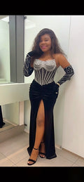 Woman wearing black beaded corset velvet gown with thigh high slit and gloves elegant evening dress
