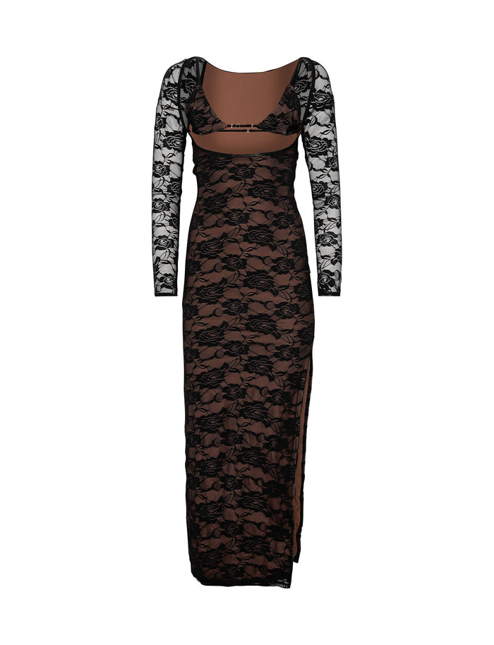 The CHRISTY LACE L/S MAXI DRESS - BLACK from TIGERMIST is a long lace dress with long sleeves, featuring a sheer brown underlayer. The dress has a scoop neckline and boasts an intricate floral lace pattern. It includes a cutout at the midriff and features a high slit on one side.