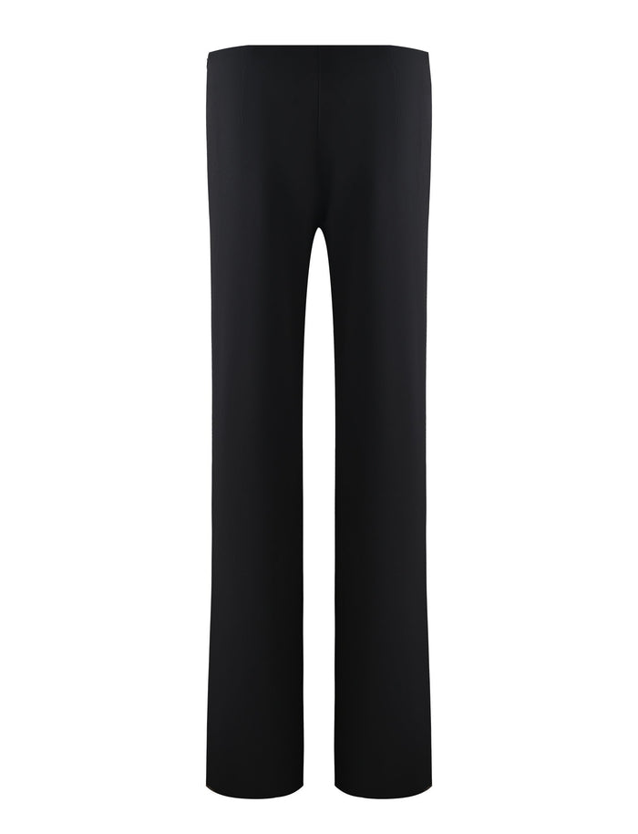 The DAMIRA PANT - BLACK from TIGERMIST is a pair of plain black, straight-leg pants viewed from the front, showcasing a simple design with no visible pockets or embellishments. The fabric appears smooth and the fit looks streamlined and formal, embodying the understated elegance characteristic of Tiger Mist.
