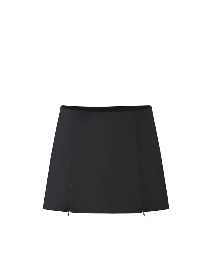 Introducing the DAMIRA SKORT - BLACK by TIGERMIST, a sophisticated high-waisted A-line miniskirt. This sleek design boasts subtle seams, giving it a slightly structured appearance. The front is adorned with small slits, adding a delicate touch of detail to its minimalist style.