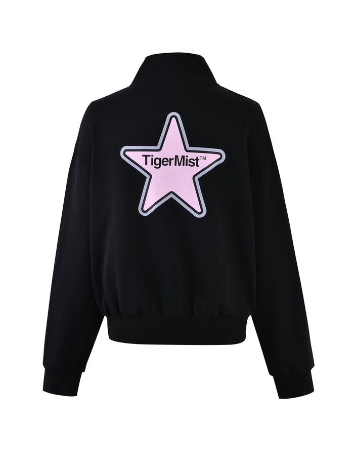 The back view of the DELFINA JUMPER - BLACK showcases a large pink star with the text "TIGERMIST" centered within it. The jumper, featuring a collar and ribbed cuffs, is part of the TIGERMIST brand collection.