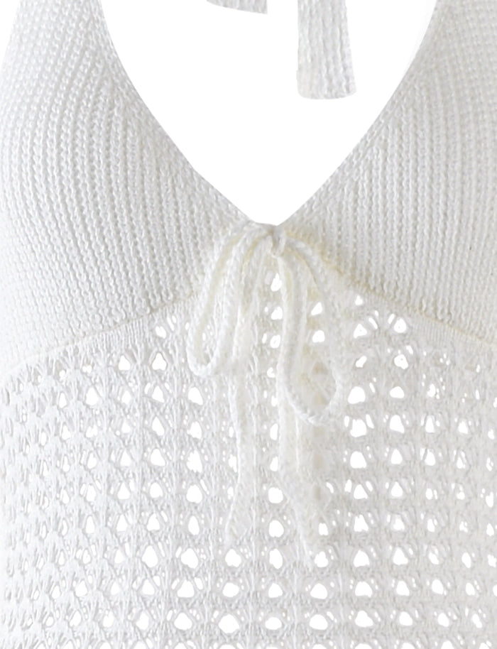 Close-up of the DELTA DRESS - WHITE from TIGERMIST showing the intricate knitted pattern. The dress features a V-neck with a tie in the center, alongside a delicate, airy design at the bust area, showcasing a combination of solid and open weaves.