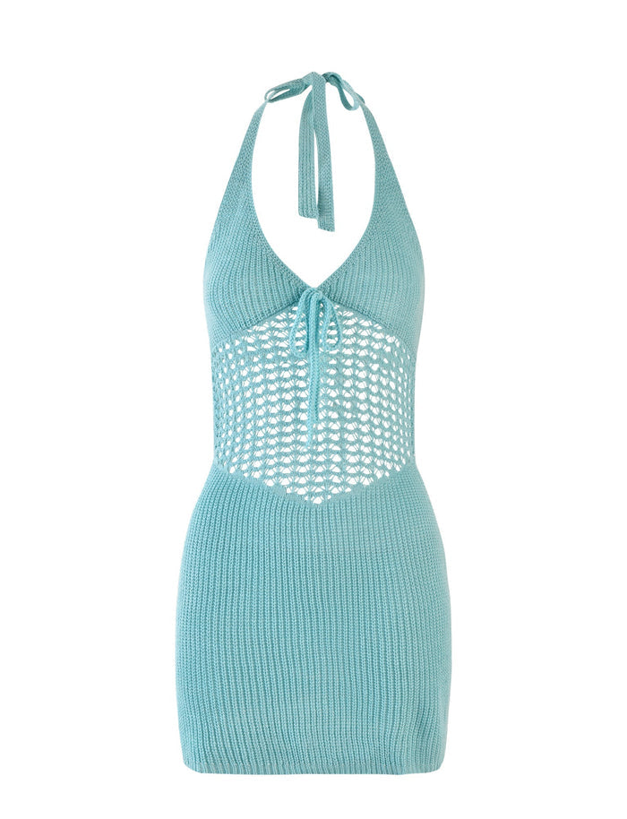 The DELTA MINI DRESS - BLUE from TIGERMIST is a pastel blue halter neck dress featuring a crochet design. The top has a tie at the neck and a keyhole cutout with detailed crochet work around the midsection, creating an alluring peek-through effect. The skirt portion is made of solid knit material, ensuring a snug and comfortable fit.