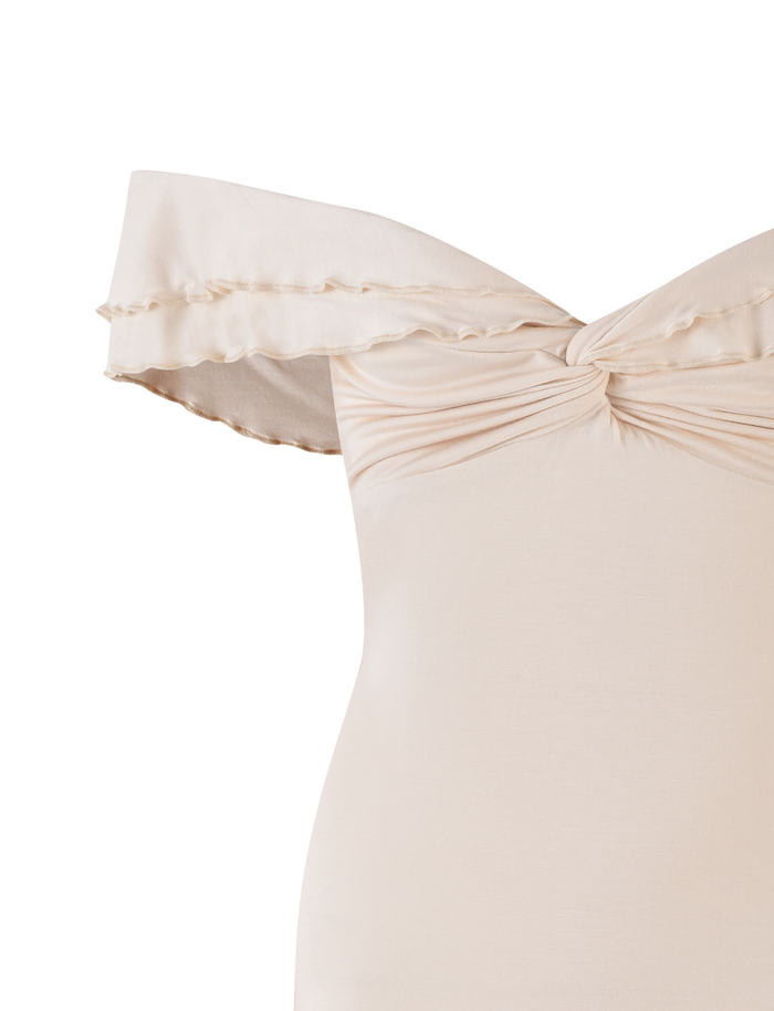 The TIGERMIST DENALI MINI DRESS in Bone is an off-the-shoulder white dress crafted from buttery jersey, featuring a twisted knot bust, ruffled neckline detail, and a fitted silhouette.