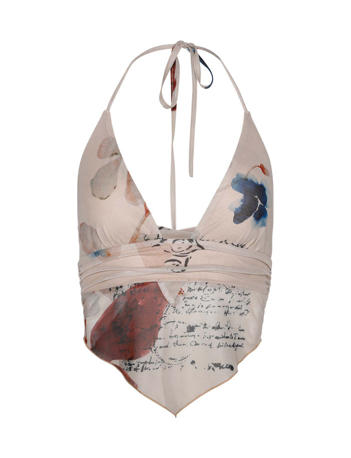 The FAYE TOP - NEUTRAL : PAISLEY : BY POPPY BUTTERFLY by TIGERMIST is a halter top with a deep V-neck, featuring a paisley pattern and handwritten script design. This light beige top is decorated with red, blue, and black accents and includes a ruched band under the bust, along with an asymmetrical hem. It ties at the neck with thin straps.