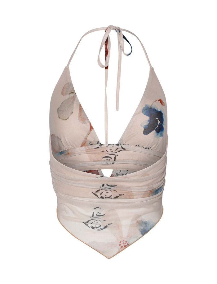 The Faye Top from TigerMist features a halter-style wrap design with a deep V-neck and charming paisley floral pattern. This top is primarily white adorned with blue, brown, and pink flowers. It ties at the back and has a draped, pointed hemline.
