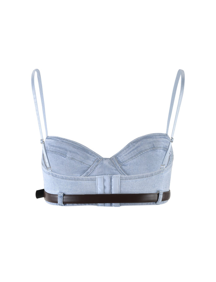The FLETCHER TOP from TIGERMIST in denim blue is a stylish crop top featuring thin adjustable straps and a sweetheart neckline. The back showcases a combination of denim and brown leather-like material, complete with a unique cutout design and buckle closure.