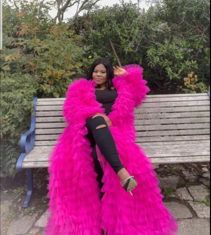 Fuschia tiered tulle statement coat styled over black outfit with layered volume