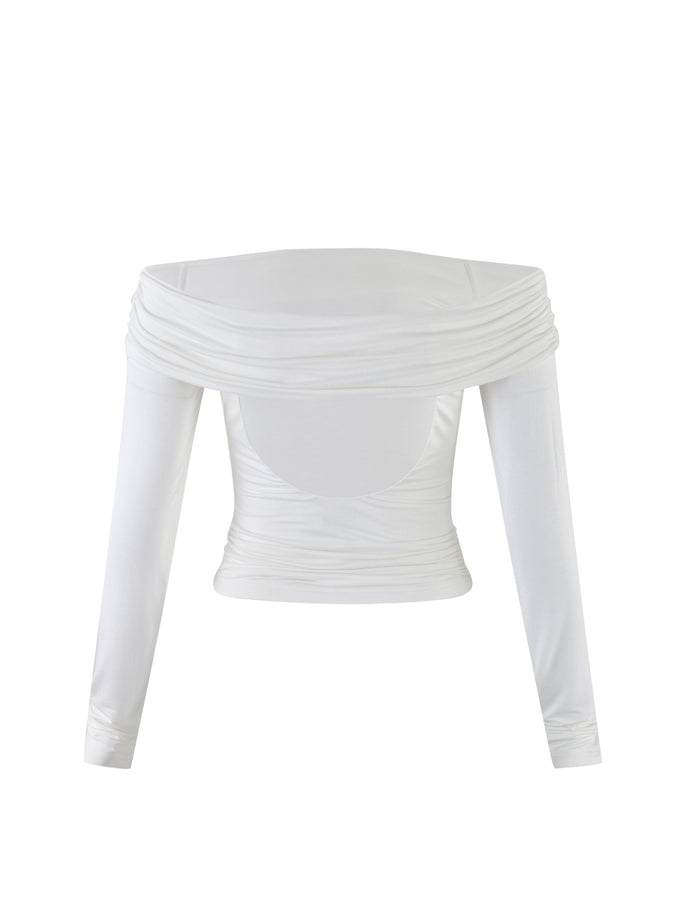 The INDIANA TOP - WHITE by TIGERMIST is a white, long-sleeved, off-the-shoulder top featuring a gathered, draped design across the chest and shoulders. The fitted fabric around the torso creates a stylish and elegant look.