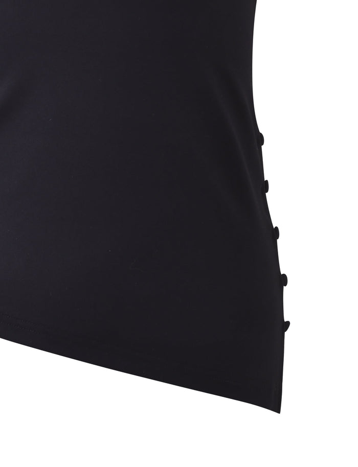 A close-up view of the INDIRA TOP - BLACK by TIGERMIST showcases a series of black buttons running vertically along the side seam. The fabric appears smooth and slightly stretchy, contributing to a simple and elegant design.