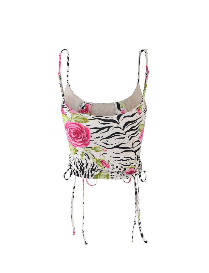 The IRIE TOP - MULTI : ZEBRA from TIGERMIST is a sleeveless crop top adorned with a mixed print of zebra stripes and bright pink roses. It features thin shoulder straps, a U-shaped neckline, and adjustable drawstrings at the hem for a customizable fit. The material is lightweight and breezy.