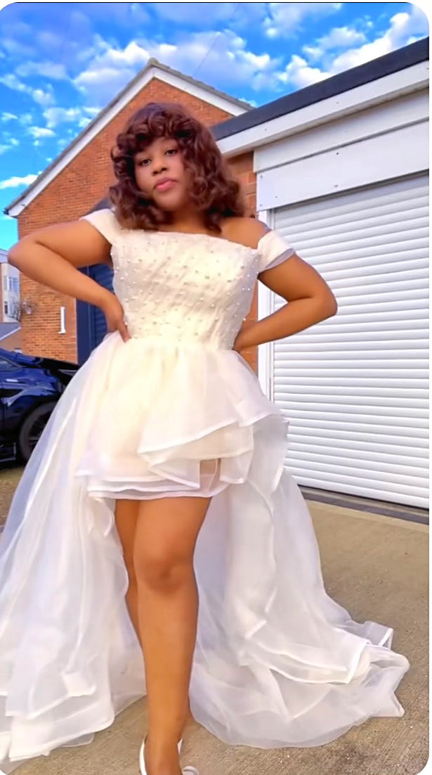 Person wearing a white high-low organza dress that is perfect for beach wedding