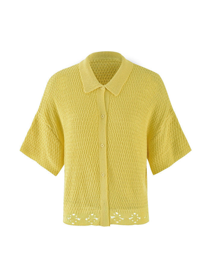A charming, lemon-yellow, short-sleeved, button-up crochet cardigan called the JANAI TOP - YELLOW : LEMON from TIGERMIST features a textured knit pattern and a collar. The hem is adorned with a small, delicate lace detail. The cardigan is beautifully displayed on a plain white background.