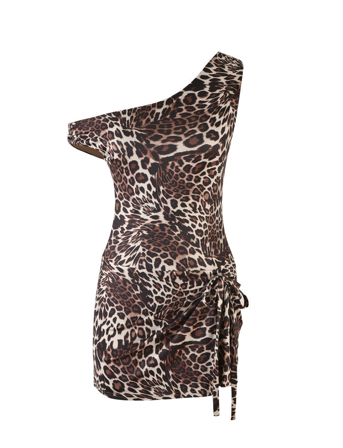 Introducing the KADENCE DRESS - MULTI : LEOPARD by TIGERMIST, a one-shoulder, form-fitting mini dress featuring an asymmetrical neckline and a chic leopard print pattern in shades of brown, black, and cream. The dress includes a stylish side tie detail and has no visible straps.