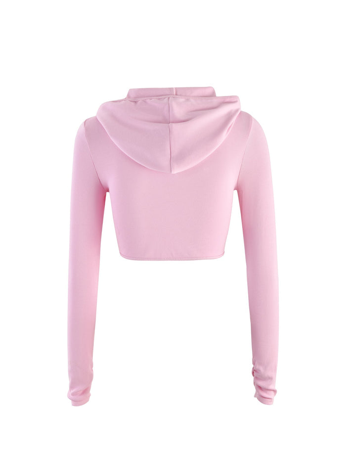 Back view of the KARINA JUMPER - PINK from TIGERMIST. This pastel pink cropped hoodie features long sleeves and a hood, made from a soft and smooth fabric. Its simple and casual design makes it ideal for a relaxed and cozy style.