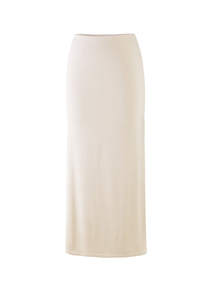 A long, fitted skirt from Tigermist, named the KAROLINA JERSEY SKIRT in off-white/ivory, is displayed on a white background. This skirt features a high waist and offers a simple, elegant design without any visible patterns, decorations, or embellishments.