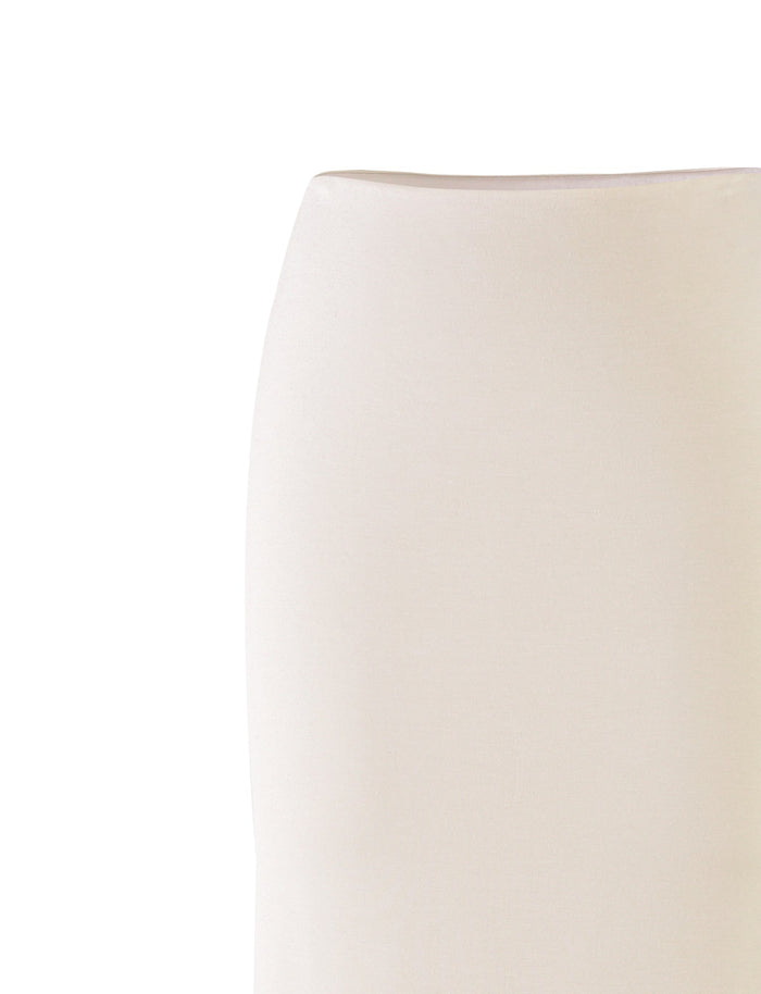 A close-up image of the backrest of an off-white KAROLINA JERSEY SKIRT by TIGERMIST, highlighting its smooth, minimalist design against a white background. The skirt exhibits a slightly curved silhouette, presenting a modern and elegant aesthetic.