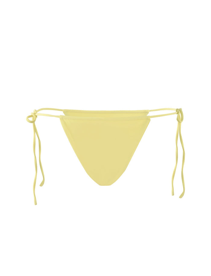 The KHESSA BIKINI BOTTOM - YELLOW : LEMON by TIGERMIST features a bright yellow color with side tie strings on both hips. This minimalist swimwear piece has a triangular front and adjustable strings for a comfortable fit. The white background accentuates the vibrant hue perfectly.