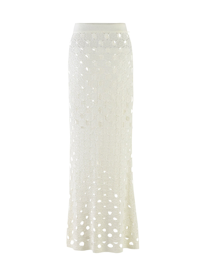The KINCADE SKIRT - WHITE from TIGERMIST is a long, elegant crochet skirt featuring a high waist and an intricate geometric pattern with small cutout details. The semi-sheer design offers a stylish, breezy look perfect for warmer weather.