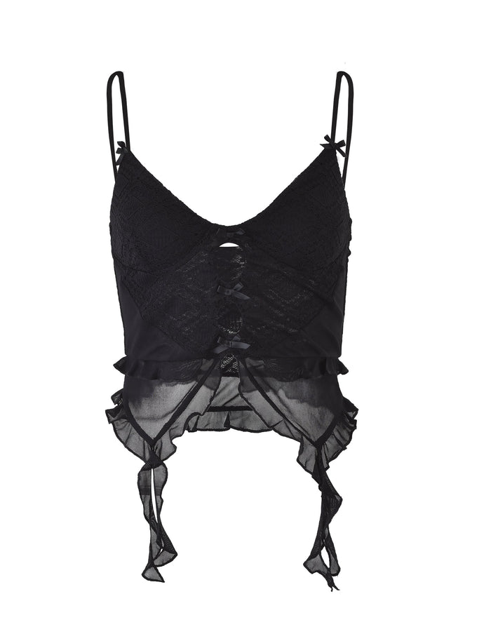 The Lafayette Top in black by TIGERMIST is a delicate lace crop top featuring thin adjustable spaghetti straps, a sheer lace-up front, and ruffled trim along the hem. The asymmetric hemline is accented with short tied ribbons at the sides and small bows on the straps, adding an edgy touch to this elegant piece.