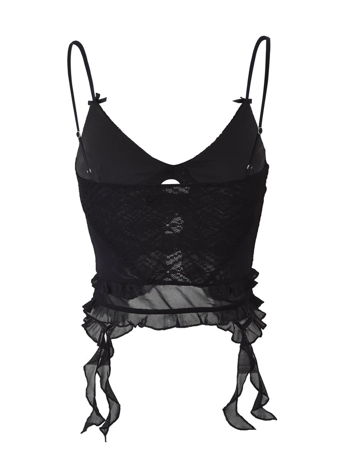 The TIGERMIST LAFAYETTE TOP in black showcases thin adjustable spaghetti straps and a small keyhole cutout beneath the V-neckline. With its lace overlay, ruffled hem, and two ribbon tie accents at the bottom, this piece exudes effortless elegance.