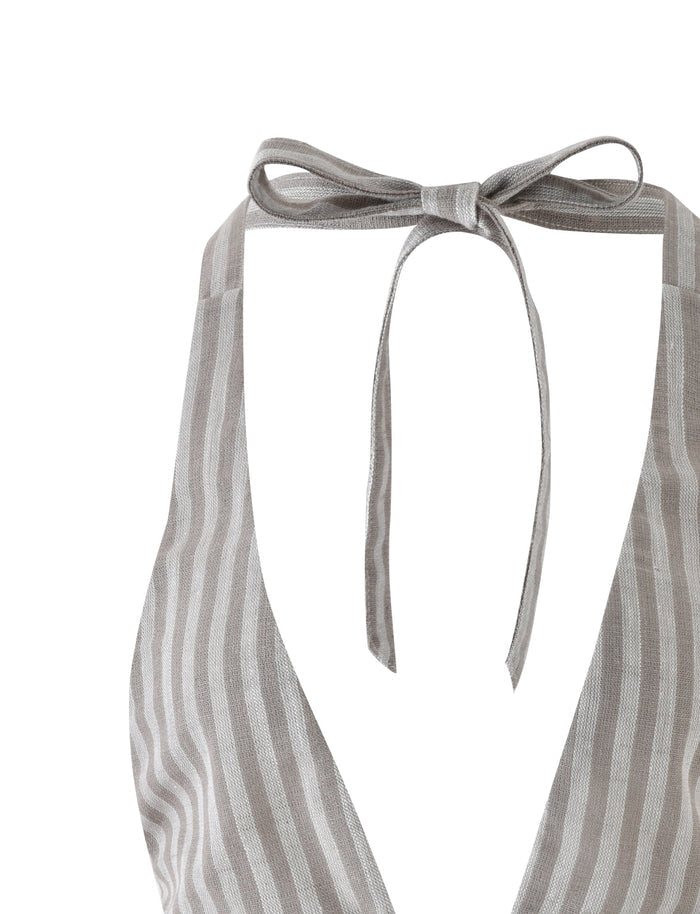 A close-up of the LAINEY TOP - GREY : STRIPE by TIGERMIST. This gray and white striped halter neck bikini top features a deep V-neck cut with straps tied into a bow at the neck. The fabric has a sheer, lightweight appearance.