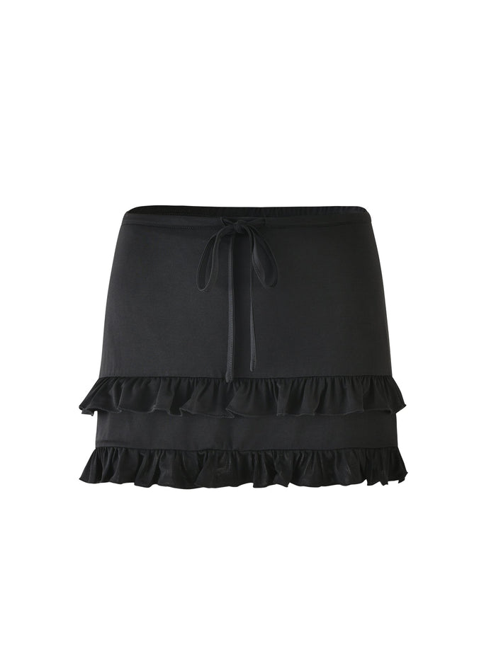 The LEOLA SKIRT - BLACK by TIGERMIST showcases a chic black short skirt design, featuring two layers of ruffles at the hem. True to Tiger Mist’s signature style, it includes a drawstring tied in a bow at the waist and has a smooth, matte fabric finish.