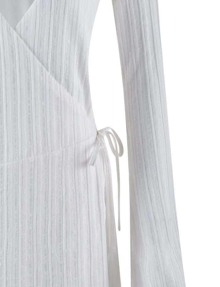 Close-up of the midsection of the LEVINS DRESS - WHITE by TIGERMIST, featuring a subtle vertical stripe texture and a thin tie at the waist.
