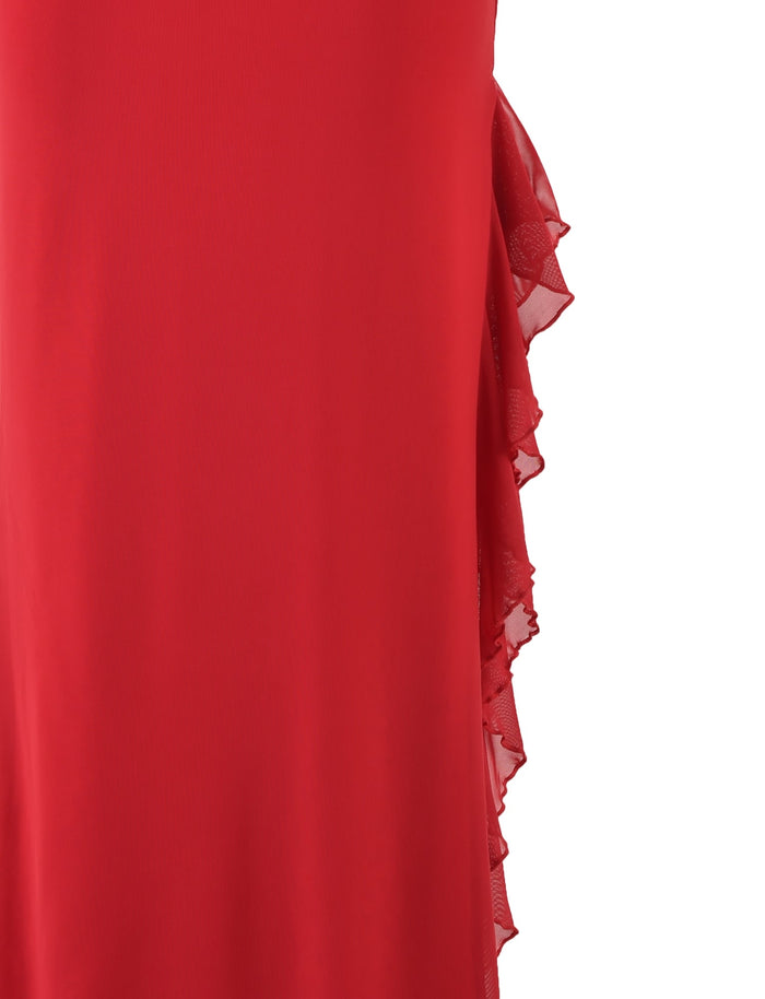 Close-up image of a flowing TIGERMIST LINETTE SKIRT in red, focusing on the side detail. The side features a series of layered, ruffled fabric, adding texture and dimension to the garment. The skirt boasts a smooth, vibrant red fabric with cascading ruffle accents.
