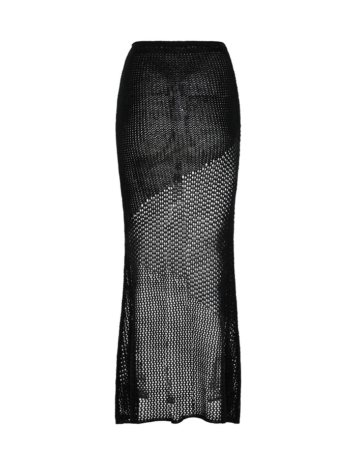 The MACAULEY SKIRT - BLACK from TIGERMIST is an ankle-length skirt that features a fitted silhouette. This black mesh skirt has an intricate netted design, providing a sheer appearance and slightly flared hemline.