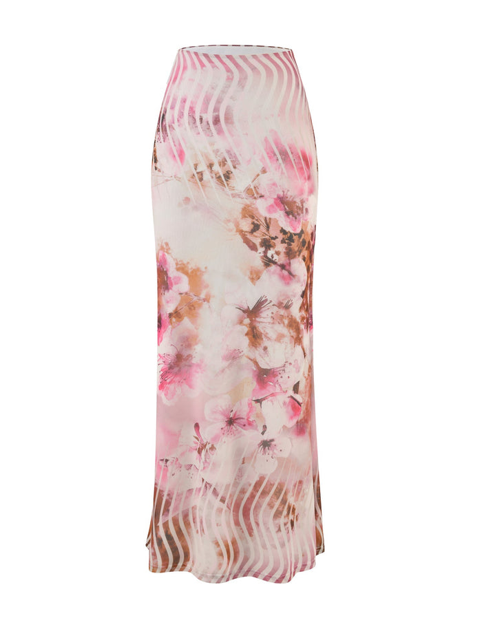 The MACEY SKIRT - MULTI : FLORAL by TIGERMIST is a high-waisted, ankle-length skirt featuring a vibrant floral pattern in shades of pink, brown, and white. This design includes a sheer overlay with diagonal white lines that create a unique, layered visual effect.