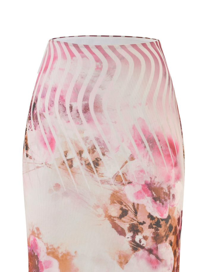 A close-up view of the Macey Skirt - Multi : Floral from TIGERMIST. The high-waisted skirt showcases a delicate pattern of pink and brown flowers intertwined with white, wavy lines that create a textured appearance. The fabric appears soft and flowy, perfect for achieving a feminine and stylish look.