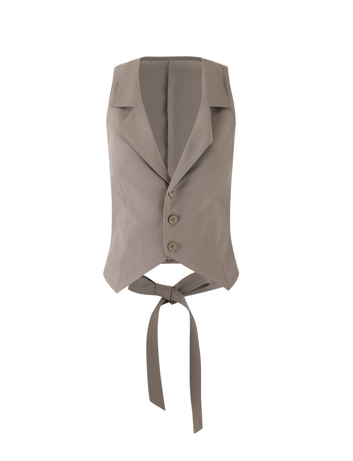 The MARJORIE VEST by TIGERMIST is a khaki, moss green sleeveless vest featuring a collar and four buttons down the front. It boasts an open back design with long ties to fasten around the waist, providing a tailored, structured look.