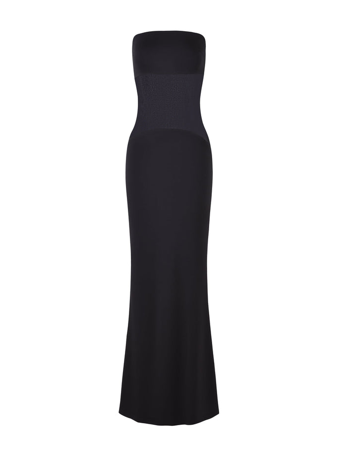 The MORGAN DRESS - BLACK by TIGERMIST is an elegant, full-length strapless dress with a form-fitting silhouette and a slight flare at the bottom. Made of smooth, slightly stretchy fabric, this dress features a subtle textured pattern on the top section for added detail.