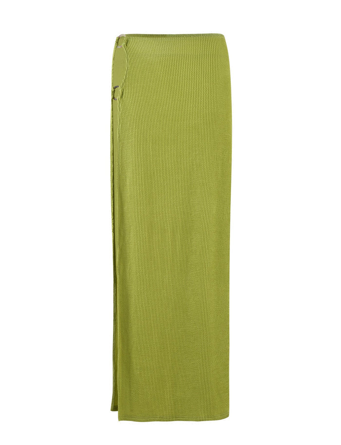 Introducing the NEERA MAXI SKIRT - LIME GREEN by TIGERMIST, a long knit skirt in an olive green hue. It features a ribbed texture, a side slit, and a decorative ring detail at the waist. Designed with a straight, streamlined silhouette, this skirt extends to ankle length.
