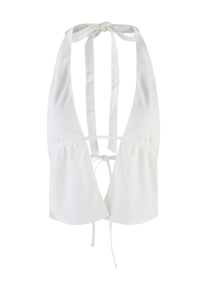 The NICOLA TOP - WHITE by TIGERMIST is a halter-neck crop top featuring a deep V-neckline and an open back. It showcases wide straps that tie at the neck and back, forming elegant bows. The lightweight yet structured fabric makes it an ideal choice for any stylish outing.