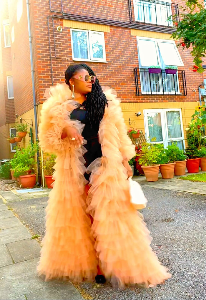 Woman in a peach ruffled statement coat ready for formal event