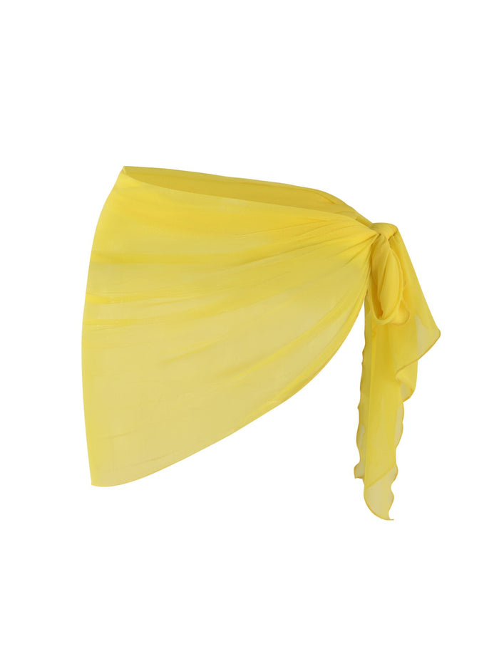 A neon yellow PEACHY SARONG from TIGERMIST tied in a stylish knot on one side, creating an elegant and flowing drape. The lightweight fabric gives it a delicate, airy appearance, making it a versatile accessory for various outfits.