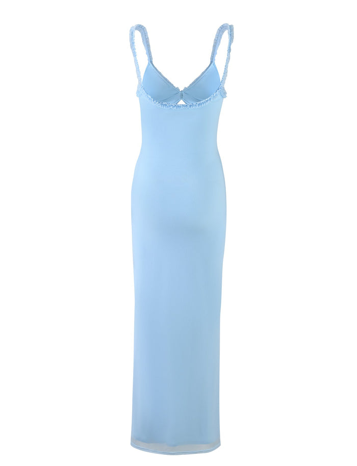The TIGERMIST RAYLA DRESS in Pastel Blue is showcased against a white background. This sleeveless, full-length dress boasts thin straps with ruffled edges and a fitted, slightly sheer silhouette.