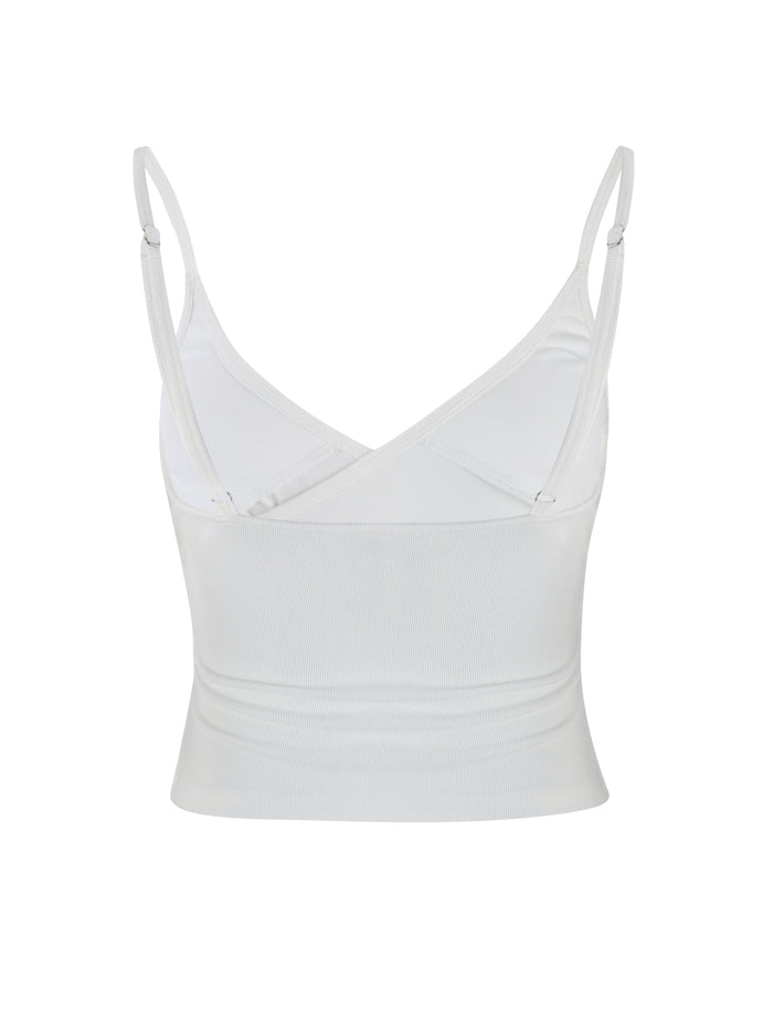 An image of the REY TOP - WHITE by TIGERMIST, a sleeveless crop top featuring adjustable spaghetti straps and a V-neck design. The top has a fitted look and is made from lightweight fabric, with a V-shaped back that offers a simple and clean style.