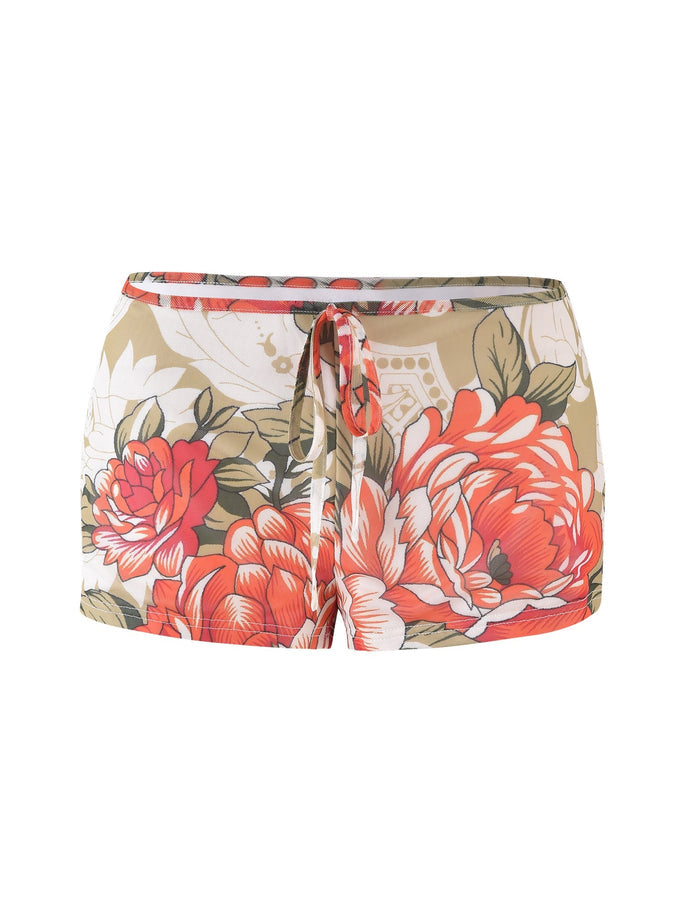 The RIOT SHORT - MULTI: MACRO FLORAL: SUNSET BLOOMS from TIGERMIST is a pair of women's shorts featuring a beige base color with a floral print in shades of red and white. These stylish shorts have an elastic waistband with a drawstring tie at the front.