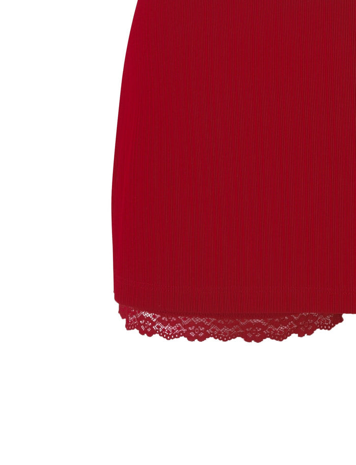 Close-up of the bottom half of the SABINE SKORT in Berry Red from TIGERMIST, showcasing a ribbed texture. Visible lace trim at the hem adds a decorative element to the garment. The background is plain white.