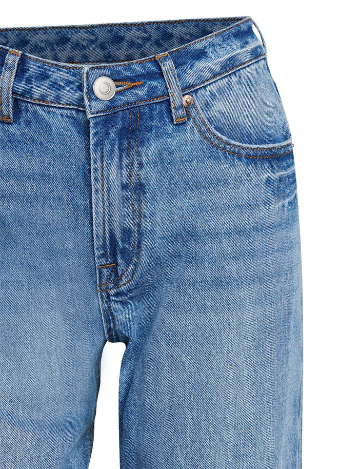 Close-up of the SACHA JEAN - MID BLUE by TIGERMIST, showcasing a classic design with a button closure, front pockets, and visible stitching. These high-waisted jeans offer a slightly faded texture for that worn-in look. The fabric ensures a relaxed straight leg fit that enhances both comfort and style.
