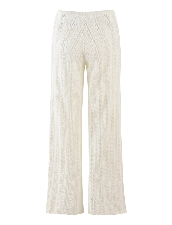 The SANDOR PANT - WHITE from TIGERMIST features a subtle chevron pattern running vertically along the fabric. These knit pants have a high waist and wide legs, offering a relaxed and comfortable fit.