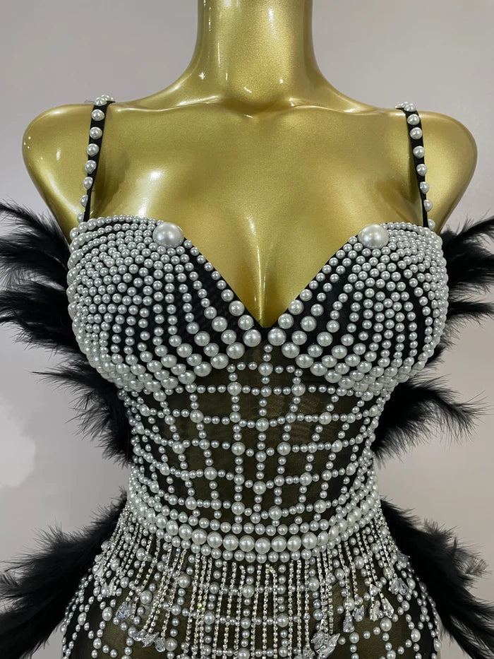 Shine in the Tabitha pearl, rhinestone, and feather mesh bodysuit. Luxury stretch outfit for stage performances, parties, and special events.