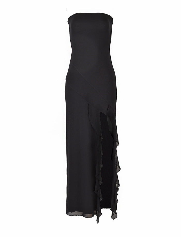 The Theo Maxi Dress in black by TigerMist is a sleek, strapless, ankle-length gown featuring an asymmetrical ruffled overlay that cascades down the front. The dress boasts a fitted bodice and a gentle, flowing skirt, creating an elegant and sophisticated silhouette.