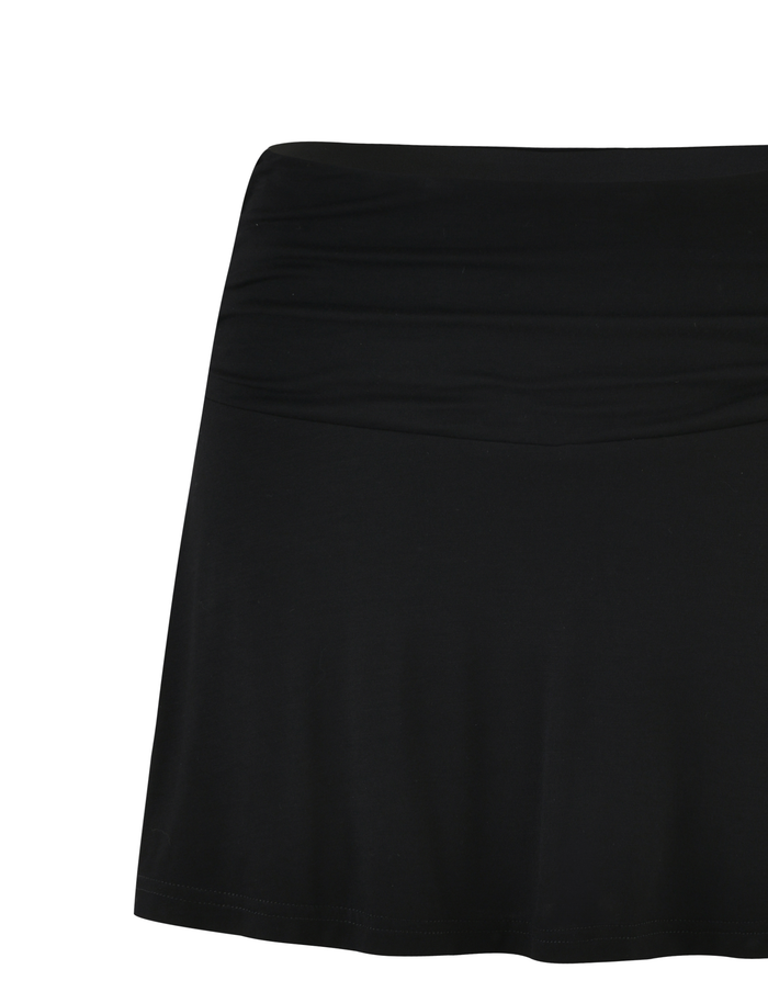 The VERITY SKORT by TIGERMIST features a bodycon silhouette, smooth waistband, and above-the-knee length in classic black, shown against a white background.