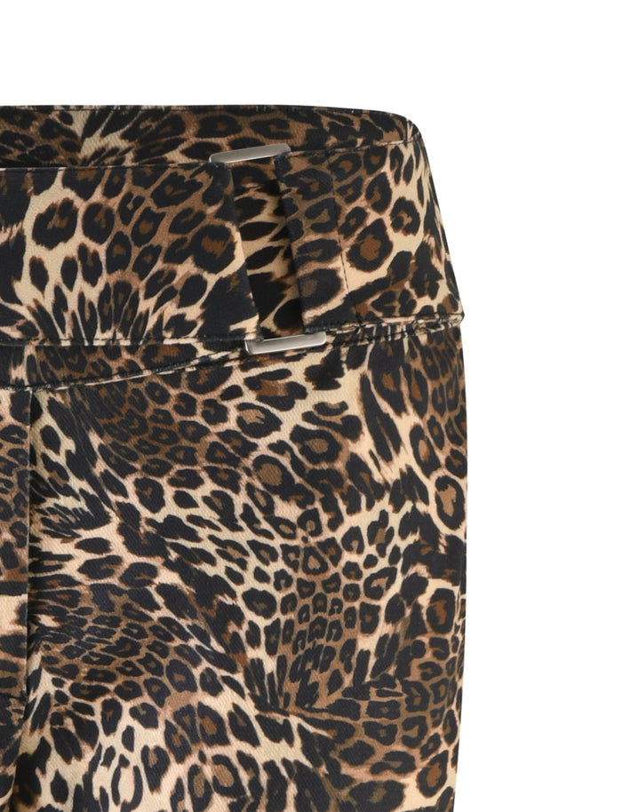Close-up image of the Vesper Pant - Multi : Leopard by TIGERMIST. The fabric showcases a diverse mix of black, brown, and tan spots resembling a leopard's coat, with part of a waistband visible in the upper portion of the image.